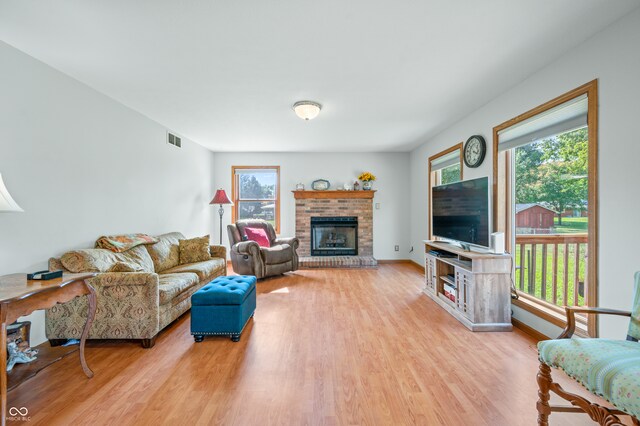 living room featuring a wealth of natural light, a fireplace, and light wood-type flooring