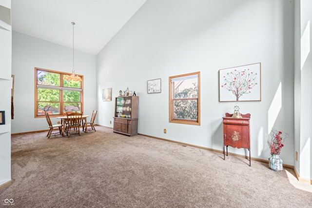 living area with carpet flooring and high vaulted ceiling