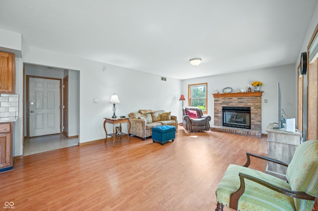 living room with a fireplace and light wood-type flooring