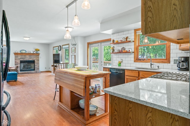 1936 Broadmoor Ln, Columbus, IN 47203 - kitchen featuring black dishwasher, a sink, backsplash, light wood-style flooring, and light stone countertops