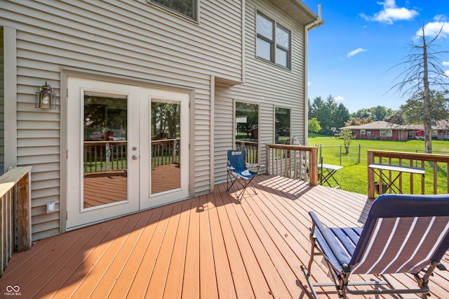 wooden terrace featuring french doors and a lawn