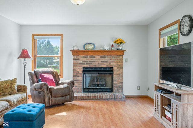 living room with light hardwood / wood-style flooring, a fireplace, and a wealth of natural light