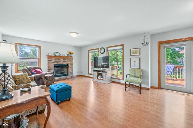 living room with light wood-type flooring and a fireplace