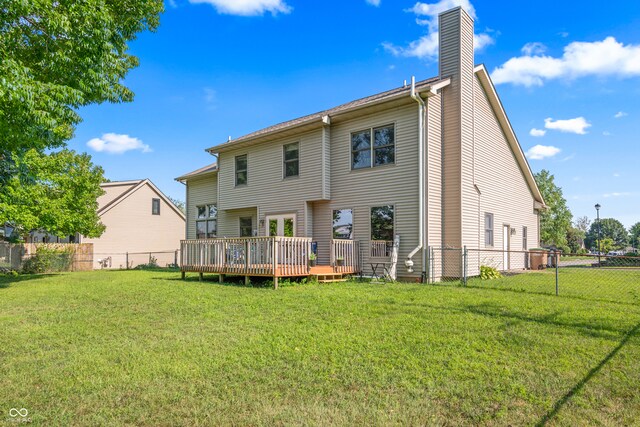 rear view of property featuring a yard and a deck