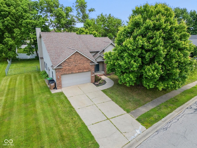 1936 Broadmoor Ln, Columbus, IN 47203 - view of front of house with a chimney, a front yard, brick siding, driveway, and an attached garage