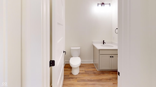 bathroom with vanity, hardwood / wood-style flooring, and toilet