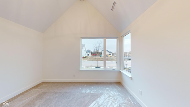 carpeted empty room featuring high vaulted ceiling