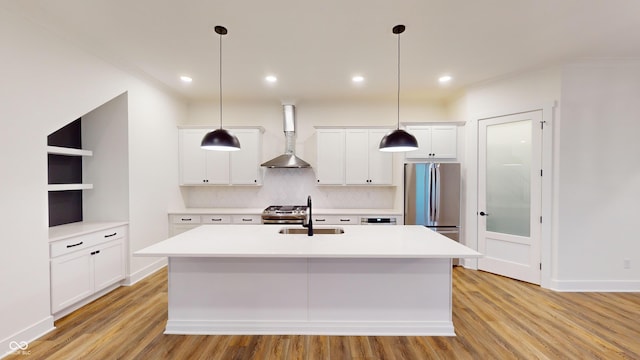 kitchen featuring white cabinetry, appliances with stainless steel finishes, sink, and wall chimney range hood