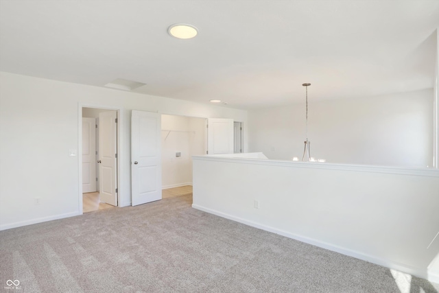 carpeted empty room featuring a chandelier