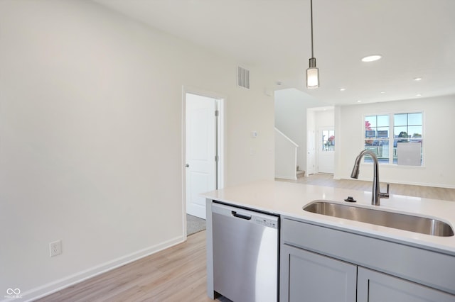 kitchen with sink, light hardwood / wood-style flooring, gray cabinets, decorative light fixtures, and stainless steel dishwasher