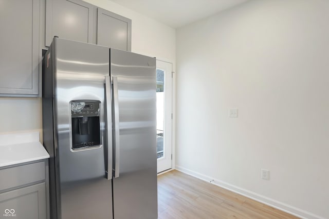 kitchen featuring gray cabinetry, light wood-type flooring, and stainless steel fridge with ice dispenser