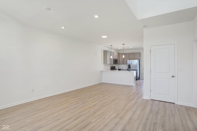 unfurnished living room with sink and light wood-type flooring