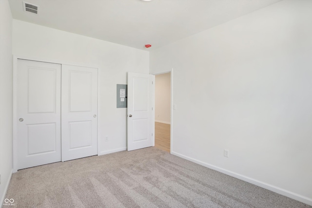 unfurnished bedroom featuring light colored carpet and a closet