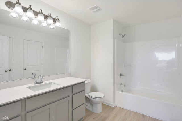 full bathroom featuring toilet, hardwood / wood-style floors, vanity, and shower / bathing tub combination