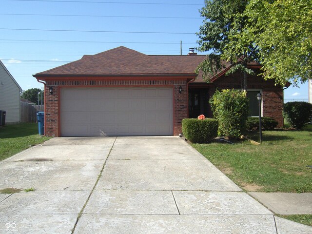 ranch-style home with a garage and a front lawn