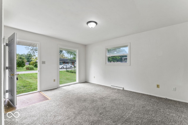 empty room with baseboard heating and carpet floors