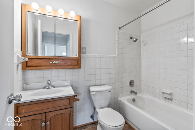 full bathroom with toilet, tile walls, tiled shower / bath, tile patterned floors, and vanity