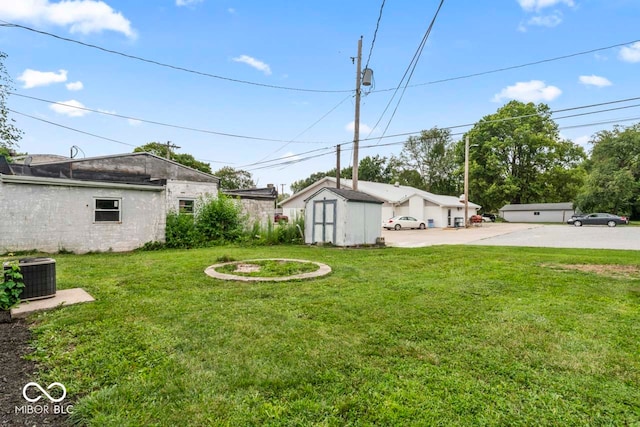 view of yard featuring a shed and central AC unit