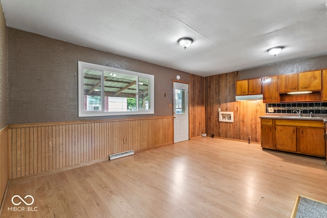 kitchen with baseboard heating, light wood-type flooring, and sink