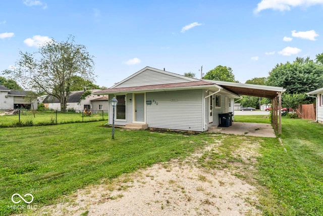 rear view of house featuring a carport and a lawn