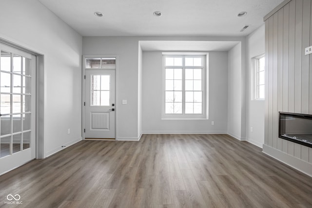 unfurnished living room with a large fireplace and wood-type flooring