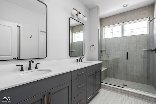 bathroom with a shower with shower door and vanity