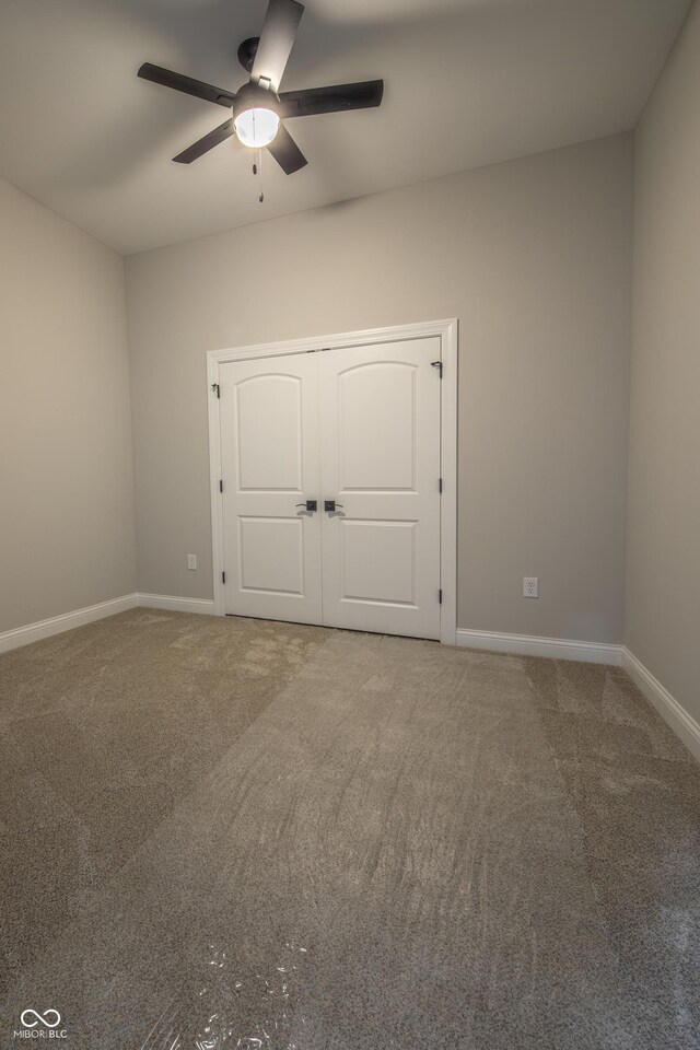 unfurnished bedroom with ceiling fan, carpet flooring, and a closet