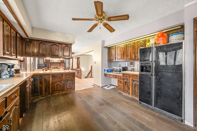 kitchen featuring kitchen peninsula, black fridge with ice dispenser, a textured ceiling, ceiling fan, and dark wood-type flooring