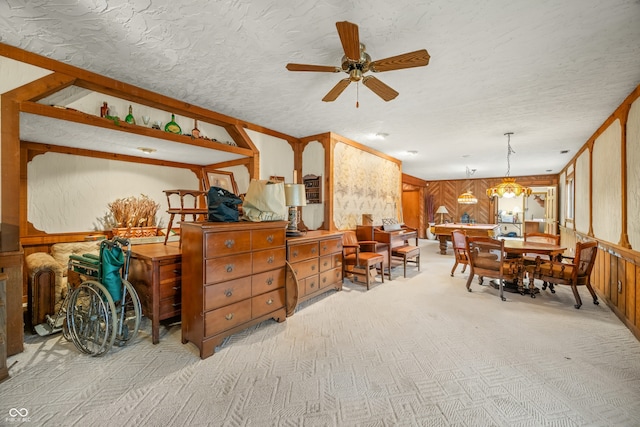 interior space with light carpet, ceiling fan with notable chandelier, and a textured ceiling