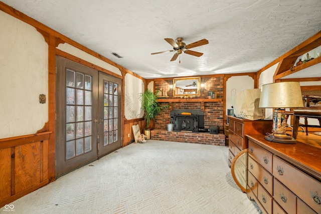 living area featuring a wood stove, wooden walls, crown molding, and a textured ceiling