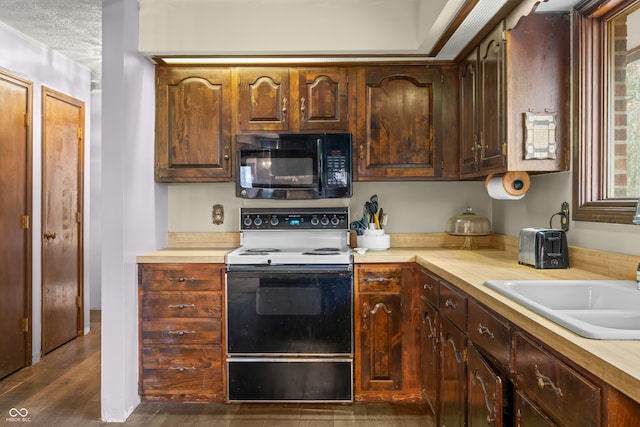 kitchen with white range with electric cooktop, sink, dark wood-type flooring, and a textured ceiling