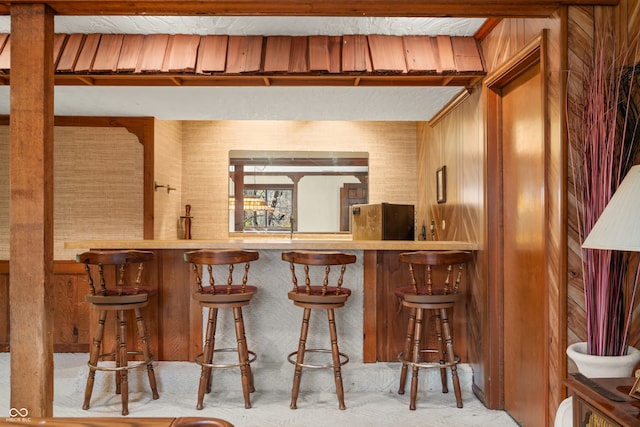 bar with stainless steel refrigerator and wooden walls