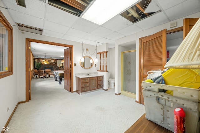 bathroom featuring a drop ceiling, toilet, an enclosed shower, and vanity