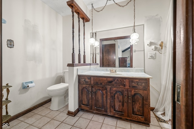 bathroom with toilet, vanity, and tile patterned floors