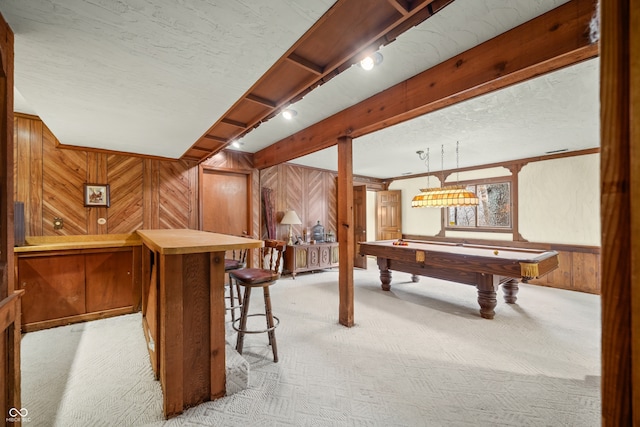 recreation room with wooden walls, light colored carpet, a textured ceiling, and billiards