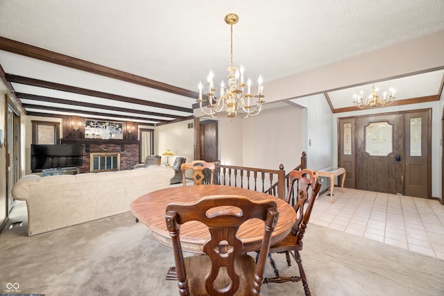 tiled dining room with a textured ceiling, beam ceiling, a fireplace, and an inviting chandelier