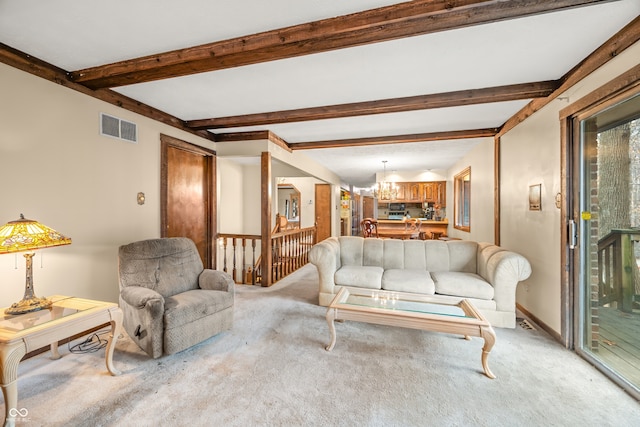 carpeted living room featuring beamed ceiling and an inviting chandelier