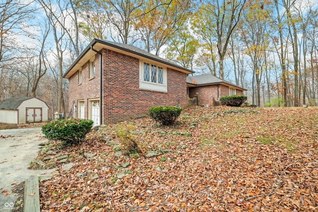 view of home's exterior featuring a garage and a storage unit