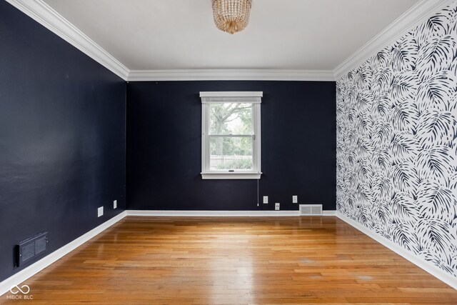 spare room with ornamental molding and light hardwood / wood-style floors