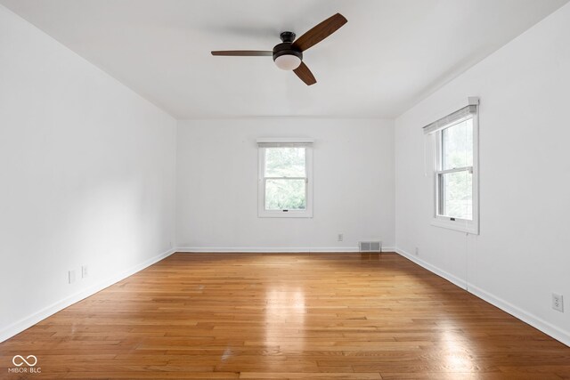 unfurnished room with a wealth of natural light, ceiling fan, and light wood-type flooring