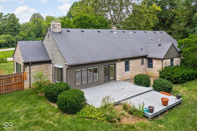 back of house featuring a lawn and a deck