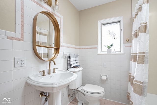 bathroom with curtained shower, tile walls, tile patterned flooring, and toilet