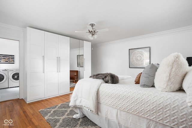 bedroom featuring wood-type flooring, ornamental molding, ceiling fan, and washer and dryer