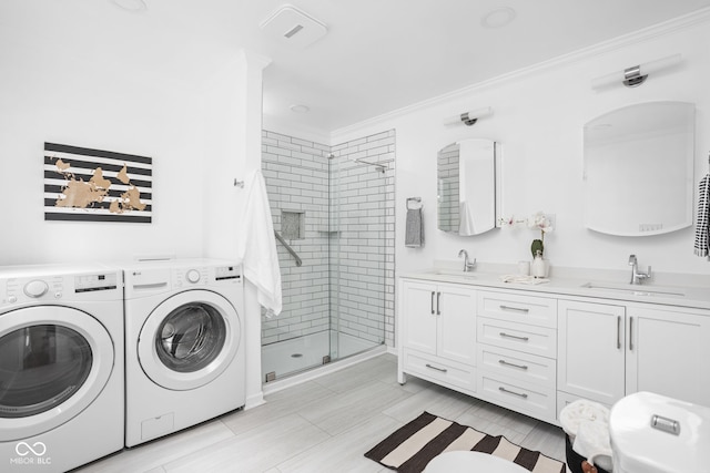 laundry room featuring crown molding, sink, and washer and dryer