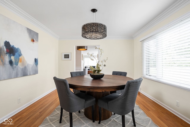 dining area with light wood-type flooring and ornamental molding