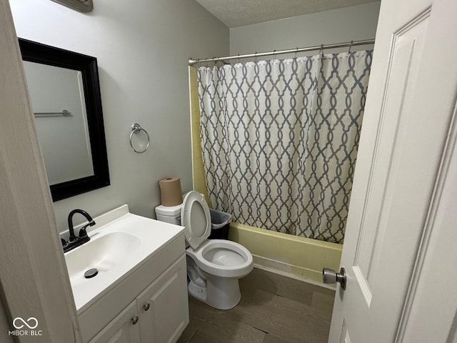 full bathroom with toilet, a textured ceiling, vanity, shower / bath combination with curtain, and hardwood / wood-style floors