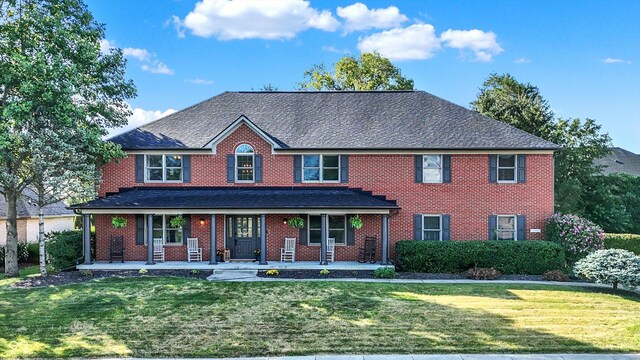 colonial house featuring a front lawn and a porch