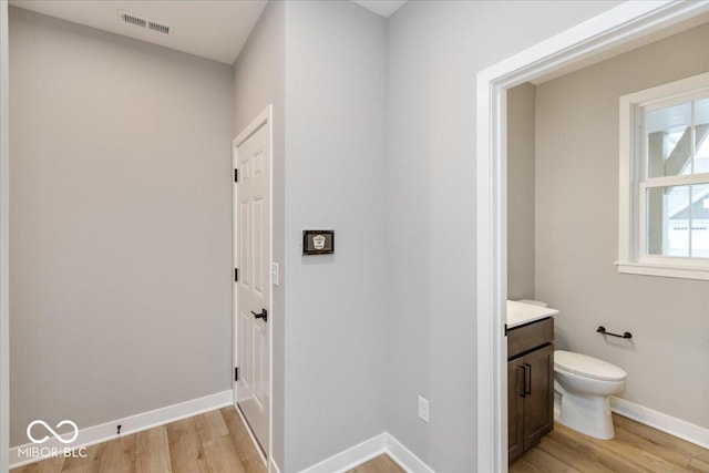 bathroom featuring vanity, toilet, and wood-type flooring