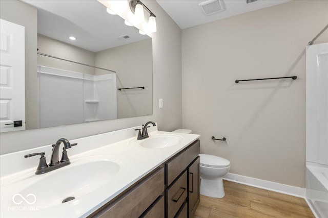 full bathroom with shower / bathing tub combination, hardwood / wood-style floors, vanity, and toilet