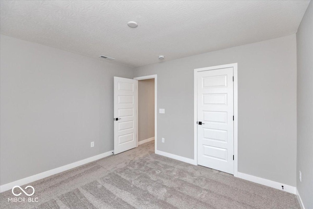 carpeted spare room with a textured ceiling